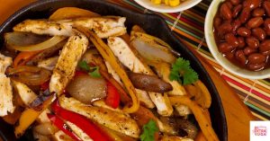Chicken fajitas in a skillet. This recipe is for Whole30 chicken fajitas that are grain, dairy, and soy-free.