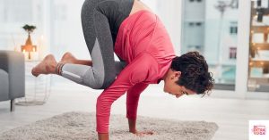 Person doing a yoga pose in the living room. This article is all about yoga challenge poses over the course of 10 days.