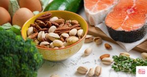Photo of healthy foods including vegetables, nuts, fish, and eggs. This article discusses foods that balance hormones in females.