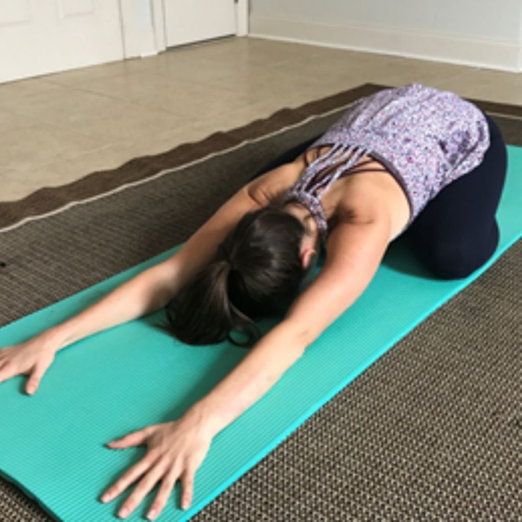 Woman doing the yoga pose called child's pose.