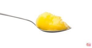 Ghee on a spoon. This article discusses if ghee can be used for hormonal balance.