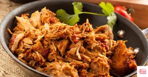 Shredded chicken in a bowl. This recipe is for paleo BBQ chicken on sweet potato buns.