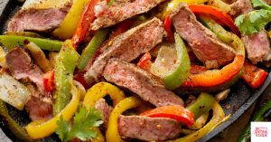 Steak fajitas in a skillet. This is a recipe for paleo beef fajitas.