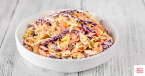 Coleslaw in a white bowl. This article shares a paleo coleslaw recipe.