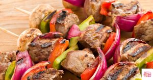 Cooked beef kabobs on skewers with onions and bell peppers. This article is a recipe for paleo steak kabobs.