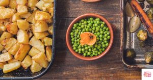 Peas and roasted potatoes on a table. This articles shares recipes for paleo side dishes.
