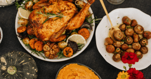 Whole chicken with mushrooms and other side dishes on a dinner table. This article shares easy anti-inflammatory recipes for breakfast, lunch, and dinner.