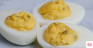 Three deviled eggs on a countertop. This article shares a recipe for paleo deviled eggs.