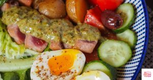 Meal with pork, egg, potatoes, tomatoes, cucubmers, and kalamata olives. This article shares easy paleo recipes.